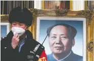  ?? NOEL CELIS / AFP VIA GETTY IMAGES ?? A security guard wearing a face mask stands beside a
portrait of the late Chinese communist leader Mao Zedong at a shopping centre in Beijing earlier this year.