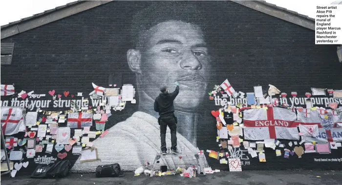  ?? AP ?? Street artist Akse P19 repairs the mural of England player Marcus Rashford in Manchester yesterday