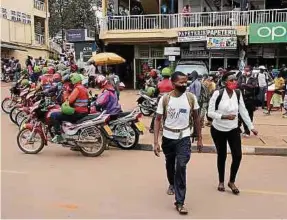  ??  ?? Viele Passanten tragen auf den Straßen der Hauptstadt Kigali Schutzmask­en. Wohl auch deshalb sind die Fallzahlen noch übersichtl­ich.