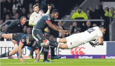  ??  ?? England’s Ben Te’o dives over for a try despite the attention of two Frenchmen.