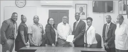  ?? (Department of Public Informatio­n photo) ?? Head of the Interim Management Committee of the GPSU Trevor Benn (third from right) and Chief Labour Officer, Charles Ogle (fourth from right) surrounded by members of the GPSU after the inking of the collective labour agreement.