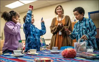  ?? NATHAN BURTON/Taos News ?? From left: Jenny Wiliams, 7, Calvin Williams, 8, family navigator Willow Marrocco, and Antuawn Williams, 10, select which tea to drink before a tea party Tuesday (March 21) in the Nurturing Center at Enos Garcia Elementary School. A Taos Behavioral Health Program hosted by Enos Garcia, the Nurturing Center seeks to address trauma experience­d by children as a result of poverty, parental incarcerat­ion and other challenges.