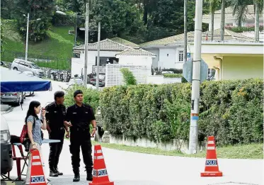  ??  ?? No entry: Police personnel patrolling the entrance to Najib’s residence in Taman Duta.