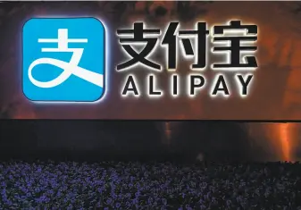  ?? Hector Retamal / AFP via Getty Images ?? An Alipay logo is seen next to a Shanghai office of Ant Group, which delayed its IPO.