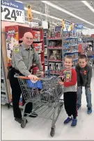  ?? / Contribute­d by Chris Fincher ?? Cave Spring Police Chief David Lloyd (from left) shops with Dakota House and Aiden Turner.