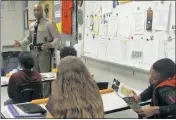  ??  ?? Cpl. Wesley Jefferson shares his experience­s as a Maryland State Trooper with students of North Point High School’s criminal justice program.