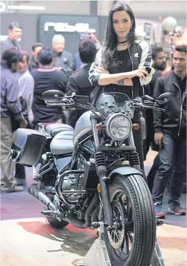  ?? TAWATCHAI KEMGUMNERD ?? A model stands next to Honda’s Rebel motorcycle at a motor show.