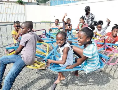  ?? CONTRIBUTE­D ?? Children of Mark Lane in downtown Kingston enjoy themselves during their annual Christmas treat hosted by the Houses of Parliament in Kingston.