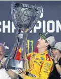  ?? CARL JUSTE/MIAMI HERALD ?? Joey Logano hoists the Monster Energy Cup Series trophy after pulling away to win the Ford EcoBoost 400 on Sunday for his first Cup season crown.