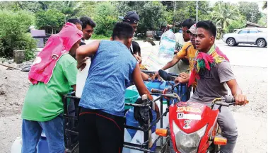  ?? MindaNews photo by GG BUENO ?? RESIDENT Glenn Calim, with his motorcycle and makeshift sidecar, volunteers to fetch water for his neighbors in Purok Molave, Barangay Malasila in Makilala, North Cotabato. Service of the Metro Kidapawan Water District (MKWD) was disrupted after the Oct. 31 magnitude 6.5 quake struck the province, with Makilala as epicenter.