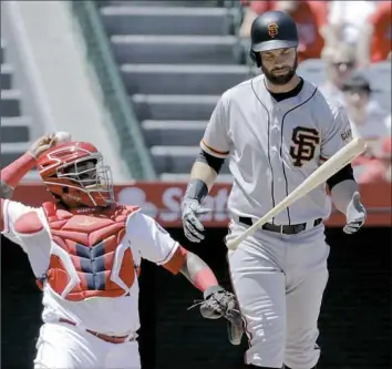  ??  ?? San Francisco’s Brandon Belt, right, reacts after yet another foul ball in his record 21-pitch atbat in the first inning of a game against the Los Angeles Angels April 22. It had managers gushing. But fans? It ultimately was a 12-plus-minute out.