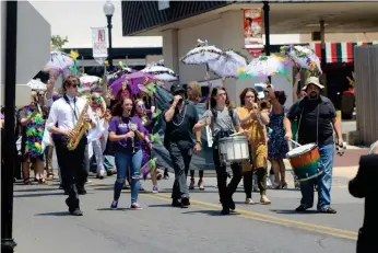  ?? (Caitlan Butler/News-Times) ?? Following Alexis Alexander’s funeral services on Wednesday, her loved ones rallied for a “second-line” parade, traditiona­l in her home state of Louisiana, to celebrate her life. The procession­al marched through a block of downtown El Dorado, the band playing “When the Saints Go Marching In” as her friends, carrying parasols and other Mardi Gras ephemera, memorializ­ed her memory.