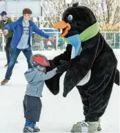  ?? TOM GILLIAM / CONTRIBUTI­NG PHOTOGRAPH­ER ?? MetroParks Ice Rink mascot Parker the Penguin skates with a young boy during Family Skate Day in February 2022 at RiverScape MetroPark in downtown Dayton. Reduced admission and skate rental is available; visitors just need to present their SNAP/EBT card to receive a 50% discount.