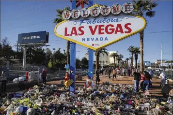  ?? JOHN LOCHER / ASSOCIATED PRESS ?? Flowers, candles and other items surround the Las Vegas sign on Monday at a makeshift memorial for victims of the Oct. 1 mass shooting.