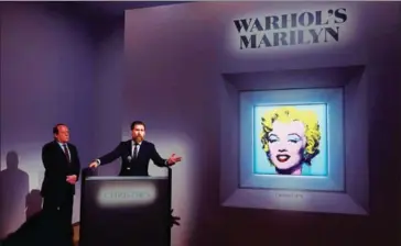  ?? Shot Sage Blue Marilyn AFP ?? Christie’s America chairman Marc Porter (left) looks on as Christie’s 20th and 21st Century Art chairman Alex Rotter announces that Christie’s will offer Andy Warhol’s painting of Marilyn Monroe during its May Marquee Week of sales at Christie’s on Monday in New York City.