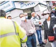  ?? RP-FOTO: ANDREAS BRETZ ?? Bezirksbür­germeister Uwe Wagner (M.) verteilt gemeinsam mit seinen Kollegen aus dem Gremium Masken an der Birkenstra­ße.