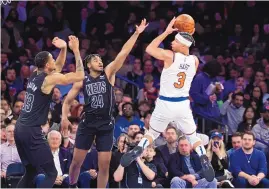  ?? JESSIE ALCHEH/ASSOCIATED PRESS ?? New York Knicks guard Josh Hart looks to pass against Brookyn’s Cam Thomas (24) and Nic Claxton during Monday night’s game. The Knicks beat the Nets 124-106, snapping a nine game losing streak against their New York rivals.