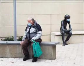  ?? Tyler Sizemore / Hearst Connecticu­t Media file photo ?? Greenwich's Earl Coyne wears a mask while waiting to pick up a book beside the beloved sculpture known as Andre, also wearing a mask, outside the Greenwich Library on Nov. 17, 2020.