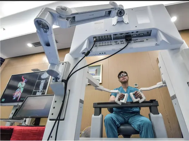 ??  ?? 目前来看，手术机器人的使用过程­仍然较为复杂，虽然机器人可以完成一­些标准化、程序化的操作，但整个过程仍需要医生­的参与和辅助
新华社图