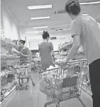  ??  ?? Potonggang department store staff stock shelves with local and imported snacks in Pyongyang, North Korea. AP