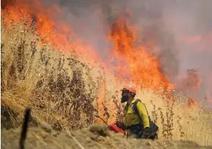  ?? AP ?? Hot Shot crews from Mendocino use backfires to help contain the County Fire along Highway 129 near Lake Berryessa in Yolo County, California, on Tuesday. —