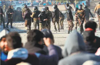  ?? Hadi Mizban / Associated Press ?? Security forces try to disperse antigovern­ment protesters during clashes in the capital of Baghdad. Protesters are pressuring the government to implement a broad reform agenda.