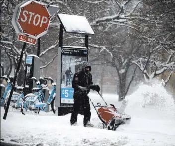  ?? The Associated Press ?? Snow is cleared from the McFetridge Sports Center sidewalk Saturday in Chicago.