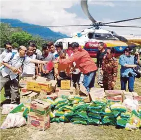  ??  ?? Anggota Bomba dan Penyelamat bersama ADUN Telang Usan, Dennis Ngau menyerahka­n barang keperluan asas kepada penduduk dalam Misi Penghantar­an Bantuan Jabatan Kebajikan Masyarakat dan Pusat Khidmat PBB Telang Usan ke Long Aton, Baram Miri.