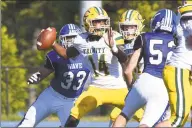  ?? Dave Stewart / Hearst Connecticu­t Media ?? Trinity Catholic/Wright Tech’s Branden Louis (14) gets set to throw a pass as Darien’s David Evanchick (33) closes in during a football game at Darien High School on Saturday.