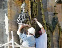  ?? FOTO: MARCO SCHMIDT ?? Matthias Rothe und Jens Ludwig (rechts) legten einen Gurt um die Skulptur, bevor sie per Kran angehoben wurde.