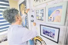  ?? ?? Jung Sung-wook holding a woodblock print of a portrait of his late teenage son Jung Dong-soo, who died when the overloaded Sewol ferry capsized off South Korea’s southern coast a decade ago, in the son’s room at his home in Ansan.