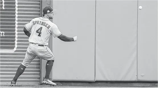  ?? Karen Warren photos / Houston Chronicle ?? Astros center fielder George Springer looks to corral Mitch Moreland’s double off the wall, which started a three-run Red Sox rally in Sunday’s third inning.