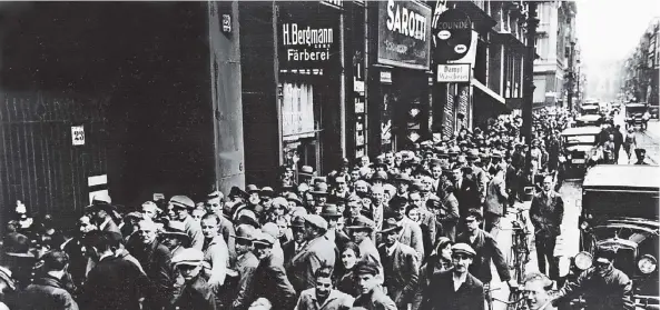  ?? FOTOS: DPA ?? Tausende Menschen stehen im Juli 1931 vor dem Berliner Postscheck­amt, um ihr Guthaben abzuheben. Sie sind in verzweifel­ter Sorge um ihr Erspartes.