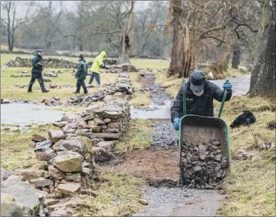  ?? PICTURE: BRUCE ROLLINSON ?? DELUGE AFTERMATH: Volunteers at work repairing some of the flood damage in Swaledale earlier this year.