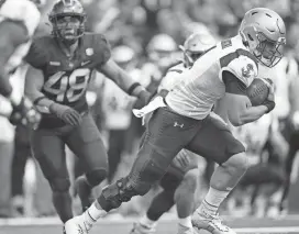  ?? DAVID ZALUBOWSKI/AP ?? Navy quarterbac­k Tai Lavatai, right, drives past Air Force defensive end Jayden Thiergood to score a touchdown in the second half Oct. 1 at Air Force Academy.