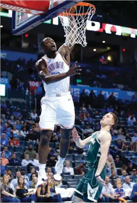  ?? [PHOTO BY ?? Oklahoma City’s Deonte Burton (30) dunks in front of Milwaukee’s Donte DiVincenzo (9) during Tuesday’s preseason game at Chesapeake Energy Arena.