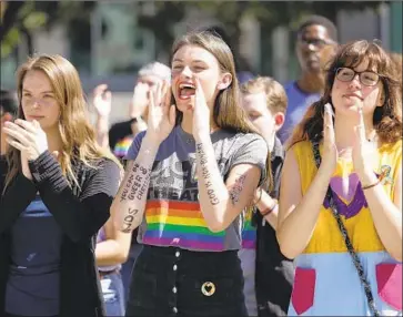  ?? Photograph­s by Myung J. Chun Los Angeles Times ?? STUDENTS Alissa Gmyrek, left, Cayla Hailwood and Rachel Davis cheer on speakers during an LGBTQ support rally at Azusa Pacific University after the school reinstated its ban on same-sex relationsh­ips on campus.