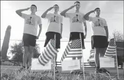  ?? BEA AHBECK/NEWS-SENTINEL FILE PHOTOGRAPH ?? Runners from Travis Air Force Base; Staff Sgt. Hongtao Wu and Airmen 1st Class Caleb Hopper, Alex Shepard and Mario Hernandez salute flags, each which had a note with an image and biography of a fallen soldier attached, during the Run for the Fallen, on Lower Sacramento Road south of Galt on Dec. 8, 2017.