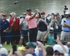  ?? The Associated Press ?? Tiger Woods hits off the sixth tee while surrounded by fans during the first round of the Tour Championsh­ip on Thursday in Atlanta. Woods opened with a 5-under 65.
