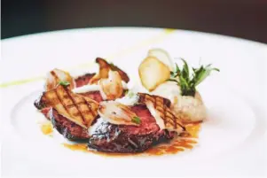  ??  ?? (clockwise from top) L’Atelier’s expertly prepared le boeuf (beef) creation; sit around the open counter and watch chef de cuisine LoreZ Hoja and his team prepare your meal; roasted brill served with stuffed Zucchini.