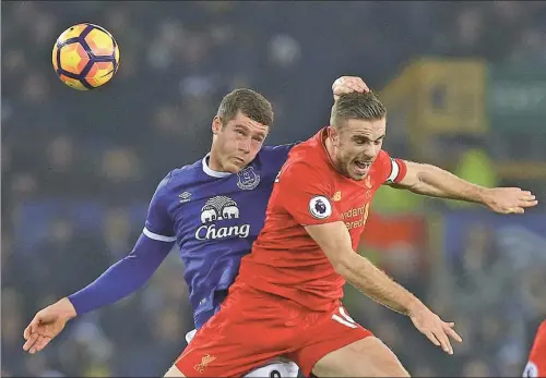  ?? DAVE THOMPSON / AP ?? Everton’s Ross Barkley (left) and Liverpool’s Jordan Henderson contest a header during their English Premier League match at Goodison Park in Liverpool on Monday. The Reds won the Merseyside derby 1-0 and moved to second in the standings, six points...