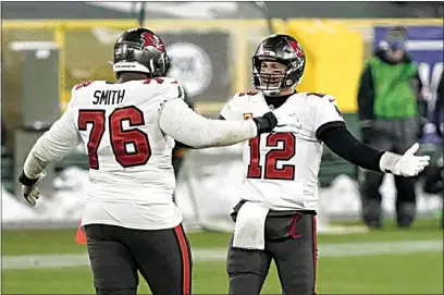  ?? MORRY GASH / AP ?? Buccaneers quarterbac­k Tom Brady celebrates with Donovan Smith after winning the NFC championsh­ip game Sunday in Green Bay, Wis.