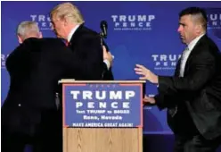  ??  ?? Trump is hustled off the stage by security agents in Reno yesterday