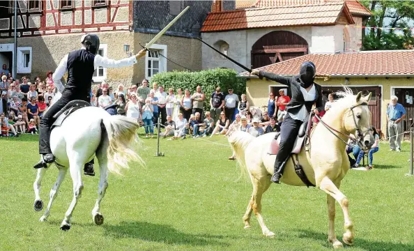  ?? FOTOS (): JENSEN ZLOTOWICZ ?? Die hohe Kunst des Reitens: Berufsreit­er Arne Koets und seine norwegisch­e Partnerin bei ihrer Dressur- und Fechtkunst- Show auf dem Platz vor der Kemenate.