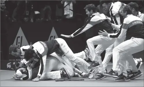  ??  ?? France’s Lucas Pouille (bottom) celebrates with his teammates after winning his singles match against Belgium’s Steve Darcis at the Davis Cup World Group final tennis match between France and Belgium in Lille, France on Sunday.