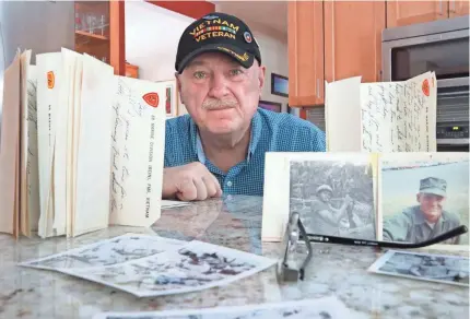  ?? MIKE DE SISTI / MILWAUKEE JOURNAL SENTINEL ?? Gary Weckworth is surrounded by photos and letters in his Glendale home from his childhood friend Wayne R. Thomas, who was killed in Vietnam three days after his 20th birthday in 1969.