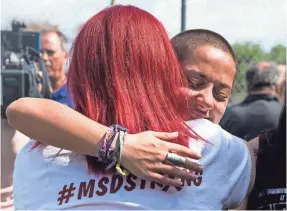  ??  ?? Emma González, 18, a senior at Marjory Stoneman Douglas High School, hugs a gun control supporter Sunday. NICOLE RAUCHEISEN/USA TODAY NETWORK