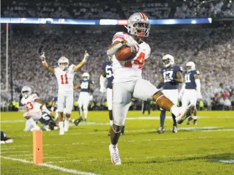  ?? Adam Cairns / Columbus Dispatch ?? Ohio State wide receiver K.J. Hill Jr. high-steps into the end zone for a 24-yard touchdown.