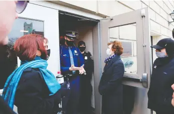  ?? JEFF KOWALSKY / AFP VIA GETTY IMAGES ?? Security officers at the Michigan Capitol deny entry to an “alternate” group of Republican electors who tried to enter the building Monday to cast votes for Donald Trump in the state that had voted for Democrat Joe Biden.