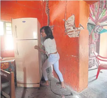  ??  ?? MOVING SCENE: Natashia, 19, an indigenous Zapotec transgende­r woman or muxe, gets her quakedamag­ed house back in order as life returns to normal.